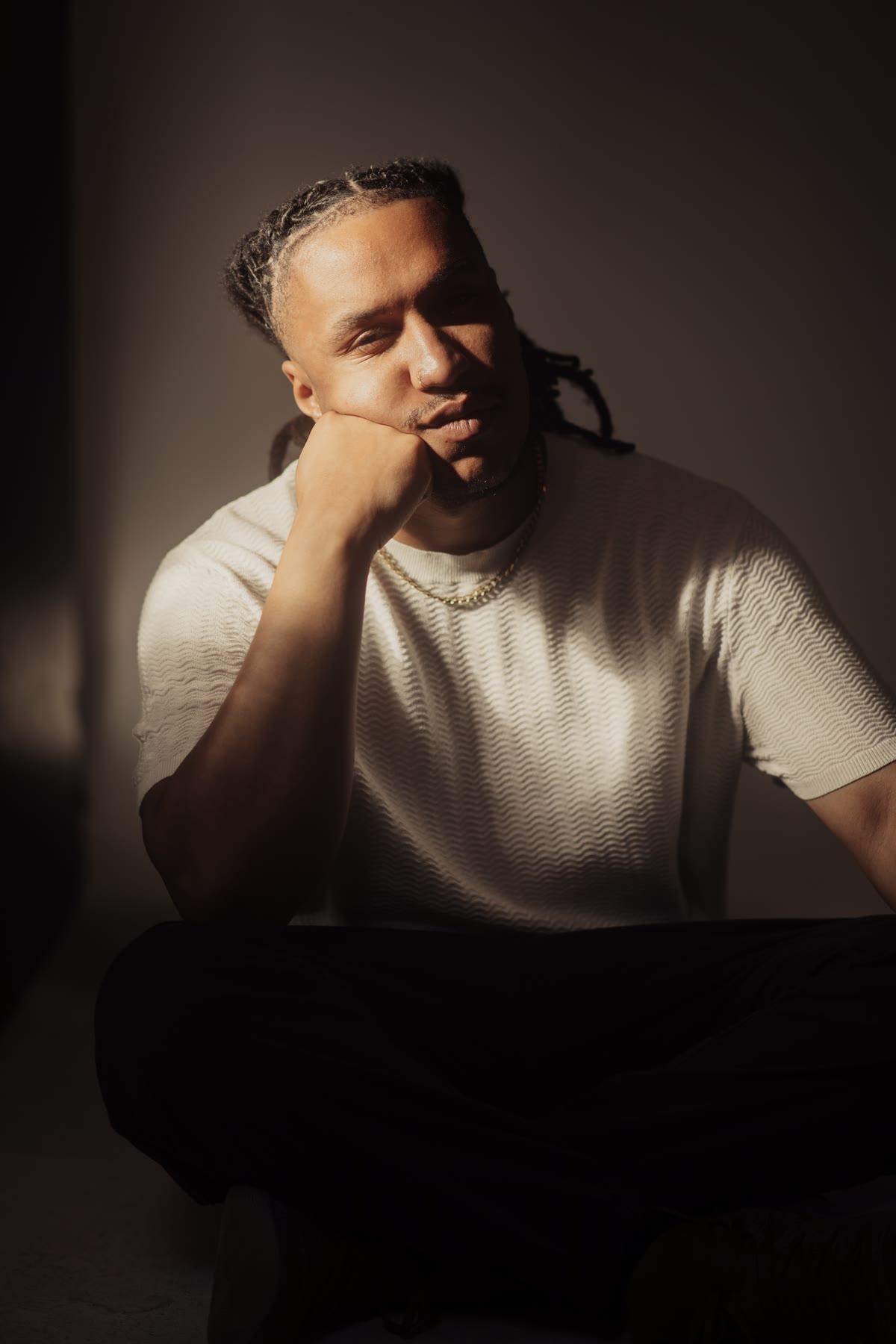 Chad the Maverick seated in studio light, chin resting on his hand